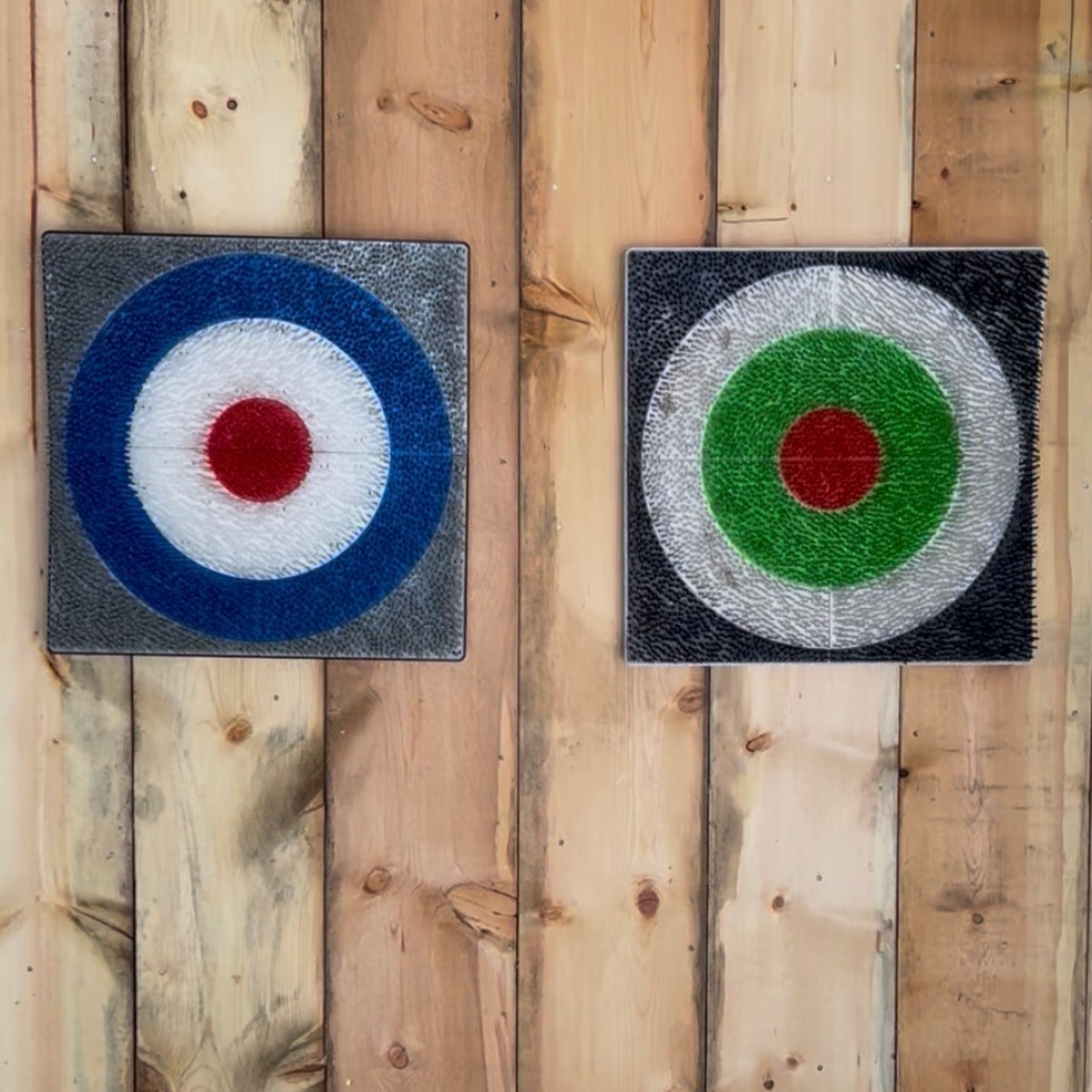 Two target paintings on wooden wall background.