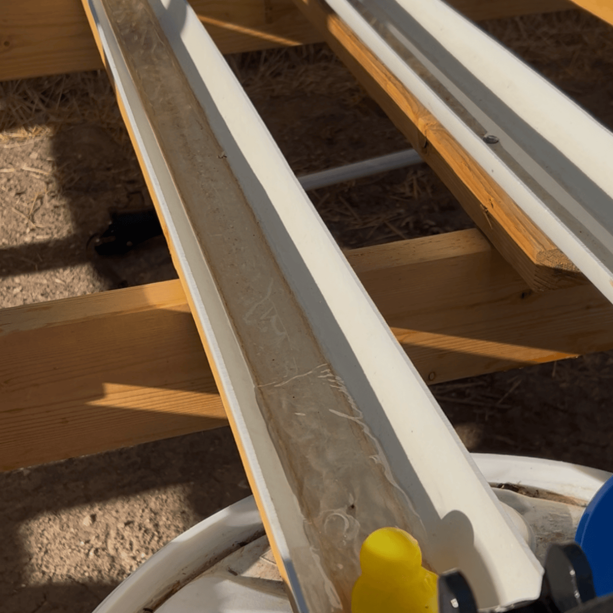 PVC pipes with algae, supported by wooden structure, outdoor